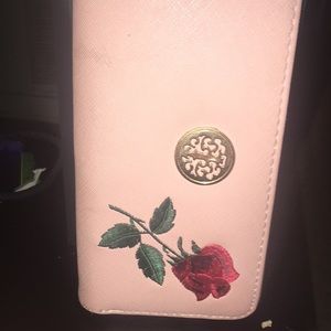 A pink wallet with rose designs.